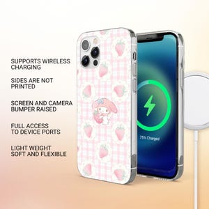 Puede incluir: Una funda de tel&eacute;fono con un estampado de cuadros rosas y ilustraciones de fresas. La funda presenta un personaje de dibujos animados sosteniendo una fresa. La pantalla del tel&eacute;fono muestra un s&iacute;mbolo de carga. El texto en la funda dice: Admite carga inal&aacute;mbrica, Los lados no est&aacute;n impresos, Parachoques de pantalla y c&aacute;mara elevados, Acceso completo a los puertos del dispositivo, Ligero, suave y flexible.