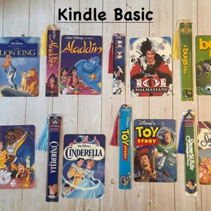 May include: A collection of Disney-themed bookmarks and book covers, featuring iconic movies like "The Lion King," "Aladdin," and "Toy Story." Each item displays vibrant artwork and includes the text "Kindle Basic."