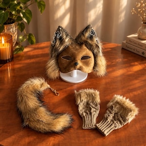 May include: A brown faux fur animal mask with pointed ears and star charms, a matching faux fur tail with a gold-tone metal clip, and a pair of beige cable-knit fingerless gloves featuring faux fur trim at the wrists and textured knit patterns.