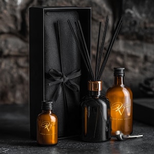 Può includere: Un set diffusore a bastoncini composto da una bottiglia in vetro nero con bastoncini neri, due bottiglie in vetro ambrato con tappi neri e un'alta scatola regalo nera legata con un nastro nero. Ogni bottiglia presenta un logo dorato.