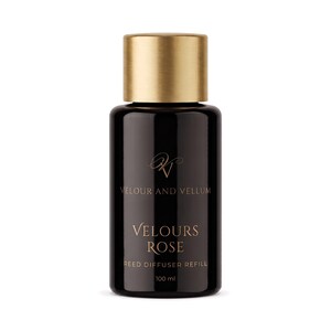 May include: A black cylindrical reed diffuser refill bottle with a metallic gold cap. The label features the text Velour and Vellum, Velours Rose, and Reed Diffuser Refill 100 ml in gold lettering. The bottle has a smooth, dark, opaque finish.