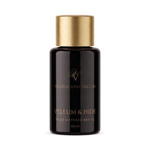 May include: A black glass bottle with a metallic gold cap containing 100 ml of reed diffuser refill. The label features the text Velour and Vellum, Vellum & Hide, and Reed Diffuser Refill in a thin, elegant, light-coloured serif font.