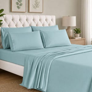 Può includere: Un set di lenzuola azzurre con federe abbinate. La biancheria da letto è disposta su un letto con una testiera trapuntata. Il set comprende un lenzuolo con angoli, un lenzuolo piano e federe, creando un'estetica della camera da letto.