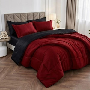 Peut inclure: Un lit avec une housse de couette rouge et noire. La literie comprend une couette rouge, deux taies d'oreiller rouges et un ensemble de draps noirs. Le lit a une tête de lit marron clair et se trouve dans une pièce bien éclairée.