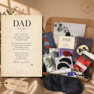 Può includere: Una confezione regalo per un futuro papà contenente un biglietto con la scritta DAD TO BE, una maschera idratante per il viso, un asciugamano grigio scuro, una bustina di caffè, patch nere per gli occhi, una fiala di vetro e una mascherina.