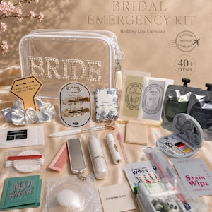 Bridal emergency kit flat lay on champagne silk showing a pearl-lettered BRIDE clear pouch surrounded by 30 or more wedding day essentials including tissues, mini toiletries, sewing kit, dress tape, blotting sheets, nipple covers, hair clips, compact mirror and stain wipe — bride to be gift box and wedding day survival kit UK