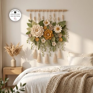 May include: A wall hanging featuring crocheted flowers and leaves in shades of cream, yellow, and green, suspended from a wooden rod with hanging tassels and wooden beads. The text Care4youStudio STEP BY STEP PDF PATTREN is visible.