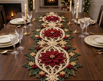 Puede incluir: Un camino de mesa rectangular de ganchillo con tres grandes flores de pascua de color rojo oscuro con centros dorados, rodeadas de patrones de copos de nieve color crema, hojas de acebo verdes y pequeñas bayas rojas sobre una mesa de madera.