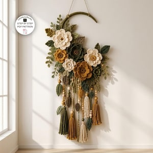 May include: A crescent-shaped wall hanging featuring crocheted flowers in cream, mustard, and dark green, accented with crocheted leaves, wooden beads, and yarn tassels. The text Care4youStudio STEP BY STEP PDF PATTREN is visible in the upper left corner.