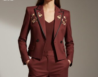 May include: A burgundy blazer and matching pants. The blazer has black trim, floral embroidery, and two buttons. The outfit is a tailored suit. The logo "JACKETIFY DESIGNS" is in the top left corner.