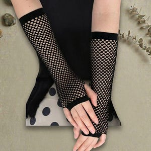 May include: Black fishnet arm warmers. These fingerless gloves extend from the wrist to the upper arm, featuring a diamond-shaped mesh design. The arm warmers are made of a stretchy material and are suitable for various occasions.