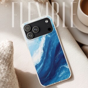 May include: A clear phone case with a blue and white wave design. The case has a black camera module and the word FLEXIBLE in white text. The phone case is on a beige surface.