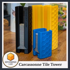May include: A black, a yellow, and a blue vertical tile tower holder, each featuring a hexagonal honeycomb pattern on the exterior. The black and yellow towers are taller, while the blue tower is shorter. Each tower displays the text HIVE MIND LABS.