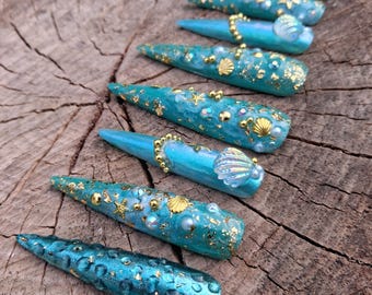 Uñas postizas XXL inspiradas en el océano con forma de tacón de aguja.