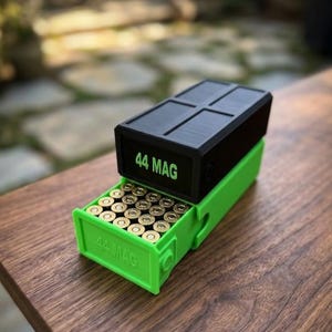 May include: A two-tone storage box featuring a black top section and a bright green sliding drawer base. The front of the black section displays the text 44 MAG in green, while the green drawer front also features the embossed text 44 MAG.