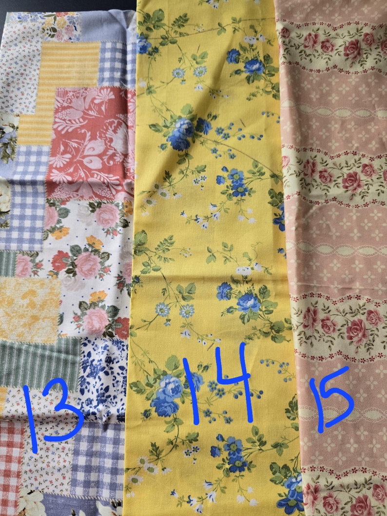 May include: Assortment of floral fabric swatches. One swatch features a patchwork design with various patterns. Another displays a yellow background with blue floral vines. The third swatch has a pink background with rose patterns.