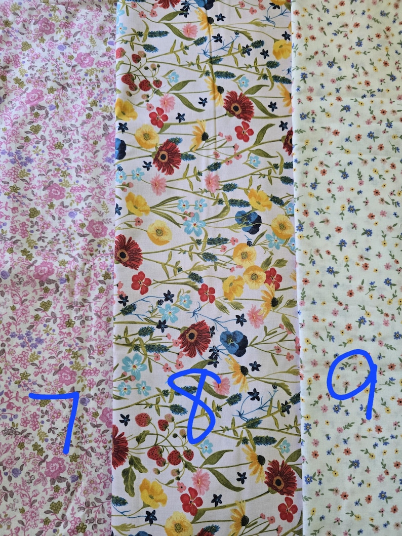 May include: Three floral fabric swatches. The first is pink with small flowers. The second is white with red, yellow, and blue flowers. The third is white with tiny yellow and pink flowers. Numbers 7, 8, and 9 are written on the fabric.