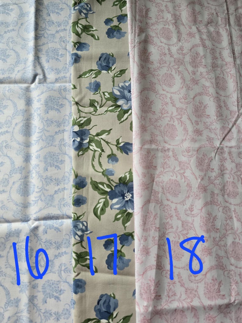 May include: Three fabric swatches with different floral patterns. One is light blue with a floral design, the second is beige with blue roses and green leaves, and the third is pink with a floral pattern. Numbers 16, 17, and 18 are written in blue.
