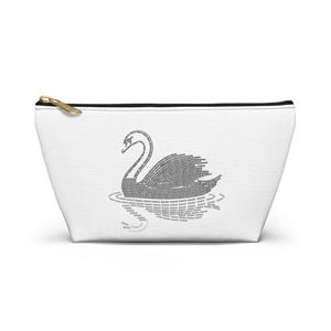 May include: White canvas cosmetic bag with a gold zipper. The bag features a black swan illustration made of the word "swan" repeated. The swan is depicted on water, also made of the word "swan".