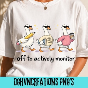 Pode incluir: Camiseta branca com um desenho de desenho animado de três gansos usando óculos de sol. Um ganso segura um lápis, outro um livro com "YOU GOT THIS" e o terceiro uma xícara de café. O texto "off to actively monitor" está abaixo.