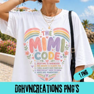 May include: White t-shirt featuring the text "THE MIMI CODE" in a colourful design with a rainbow and floral accents. The text lists rules including "Bedtime is whenever" and "Hugs are mandatory." A fun, casual top.