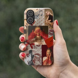 Puede incluir: Una funda de teléfono con un diseño de collage, que incluye imágenes de una mujer, notas musicales, corazones y huellas de lápiz labial. La funda tiene las palabras "Eternal Sunshine". La funda se sostiene en una mano con esmalte de uñas rojo.