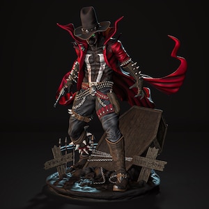 May include: A detailed figurine of a character in a black hat and red cape, holding a gun. The figure has a white chest emblem and is standing near a tombstone. The figure is wearing black pants, boots, and a belt with bullets.