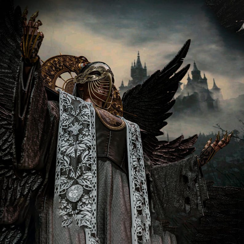 May include: A figure wearing a gold filigree mask with hanging chains, a dark textured robe with white floral lace panels, and large black feathered wings. The figure has gold claw-like finger extensions and a circular gold halo-like headpiece.