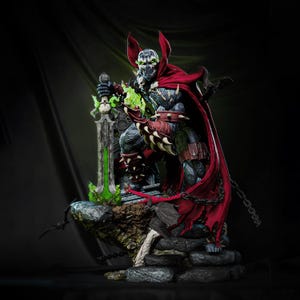 Puede incluir: Figura de acción detallada de Spawn, un personaje de cómic, de pie sobre una base de piedra. La figura lleva una capa roja, una armadura con púas y sostiene una espada verde brillante. La figura tiene una cara de calavera y está en una pose dinámica.