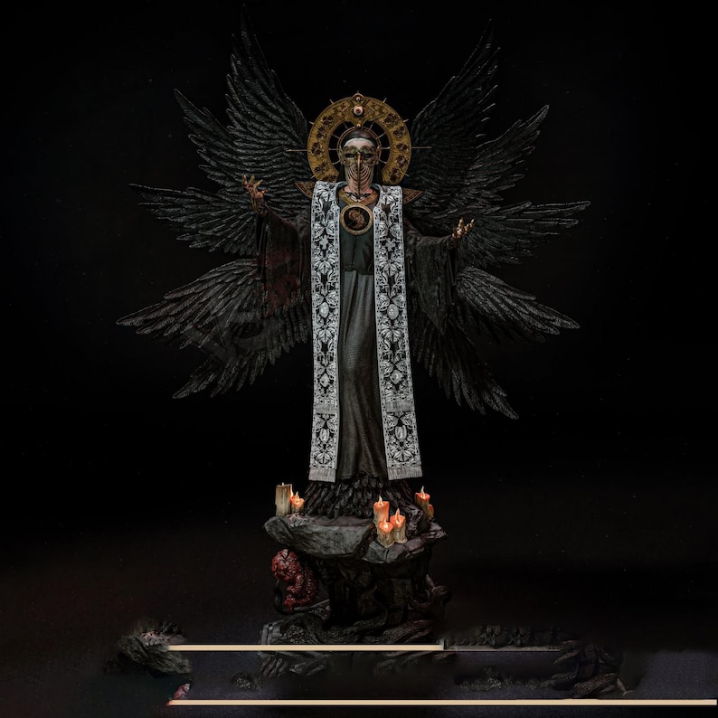 May include: A detailed figurine of a winged figure wearing a long black robe with a white embroidered stole. The figure has a gold halo, a mask, and multiple black wings. It stands on a rocky base decorated with small lit candles and a red creature.