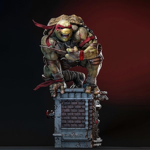 May include: A detailed statue of Raphael from Teenage Mutant Ninja Turtles. The green turtle figure is crouched on a brick structure, wearing a red mask and holding a sai. The statue has a weathered appearance.