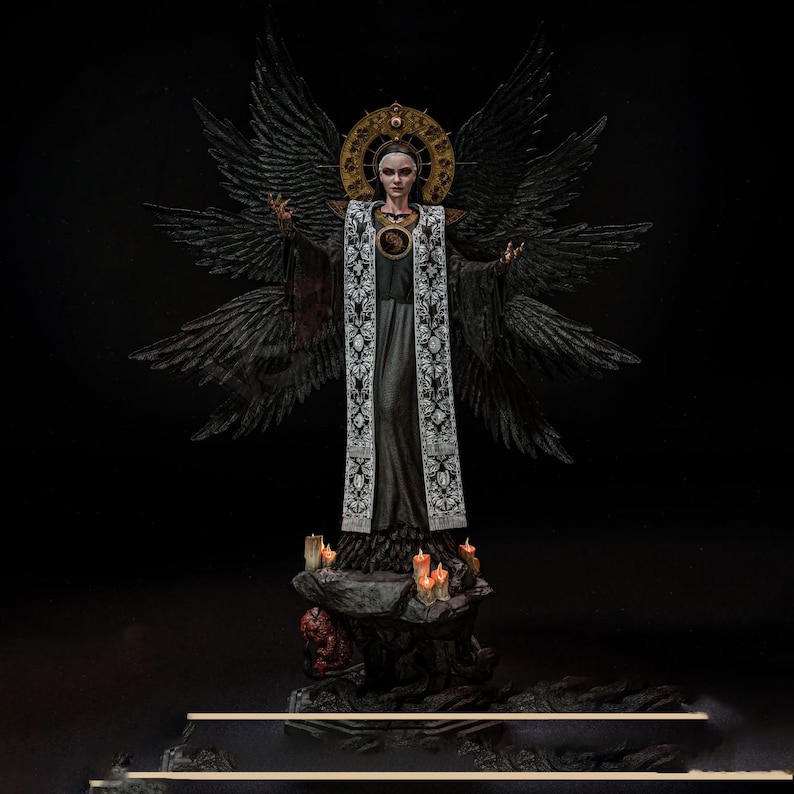 May include: A detailed figurine of a figure with large black wings, wearing a long black robe and a white embroidered stole. The figure has a gold halo behind the head and stands on a rocky base decorated with several small, lit orange candles.