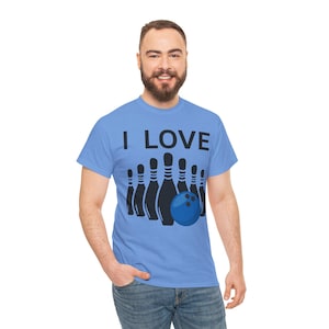 Op de afbeelding: Lichtblauw T-shirt met de tekst "I LOVE" boven een afbeelding van zwarte bowlingkegels en een blauwe bowlingbal. Het T-shirt is gemaakt van een zacht materiaal. Het ontwerp is eenvoudig en opvallend.
