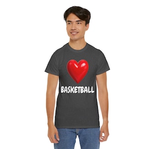 Op de afbeelding: Donkergrijs T-shirt met een rode hartafbeelding en het woord "BASKETBALL" in het wit. Het shirt is gemaakt van een zacht materiaal en is geschikt voor vrijetijdskleding. Het ontwerp is eenvoudig en gedurfd, perfect voor basketbalfans.