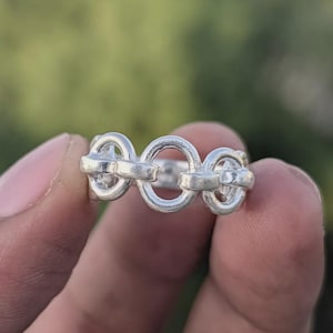 Könnte beinhalten: Ein Set aus drei Keramikbechern mit gesprenkelter, matter Oberfläche. Die Becher sind in Creme-, Hellgrau- und Dunkelgrautönen gehalten. Jeder Becher hat ein schlichtes, minimalistisches Design.