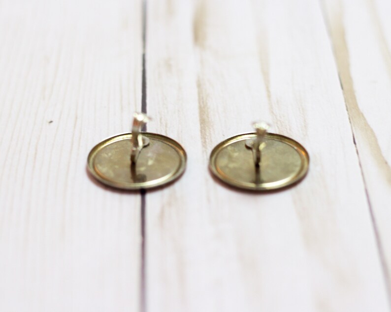 May include: Two gold-colored metal earring backs with a silver-colored hook.