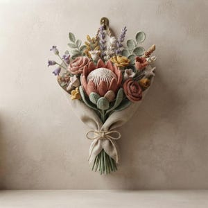 May include: A wall-hanging crochet flower bouquet featuring a large central protea, smaller roses, lavender sprigs, and eucalyptus leaves in muted tones of dusty pink, sage green, and yellow, wrapped in beige fabric tied with a simple twine bow.
