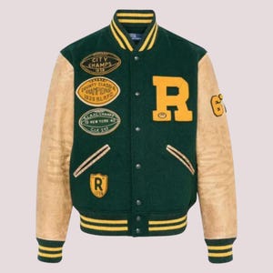 May include: A green and beige varsity jacket featuring yellow detailing and patches. The jacket has leather sleeves and the letter "R" in yellow. Patches include "CITY CHAMPS 1939" and "COUNTY CLASS CHAMPIONS 1939 RLAFC". The cuffs and hem are striped.