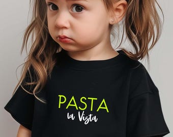 May include: A black t-shirt with the words "PASTA la Vista" printed on the front in neon green and white. The t-shirt is worn by a young child with their hair in pigtails.