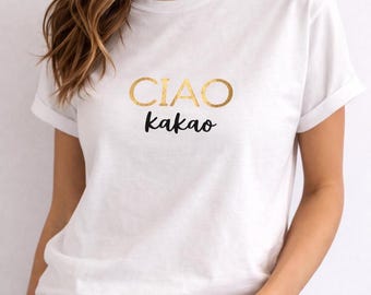 May include: White t-shirt with rolled sleeves. The shirt features the words "CIAO kakao" in gold and black lettering. The shirt is made of a soft, comfortable material.