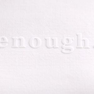May include: A close-up of a white textured surface with the word "enough" embossed in white. The word is centered and the period is visible. The background is a solid white color.