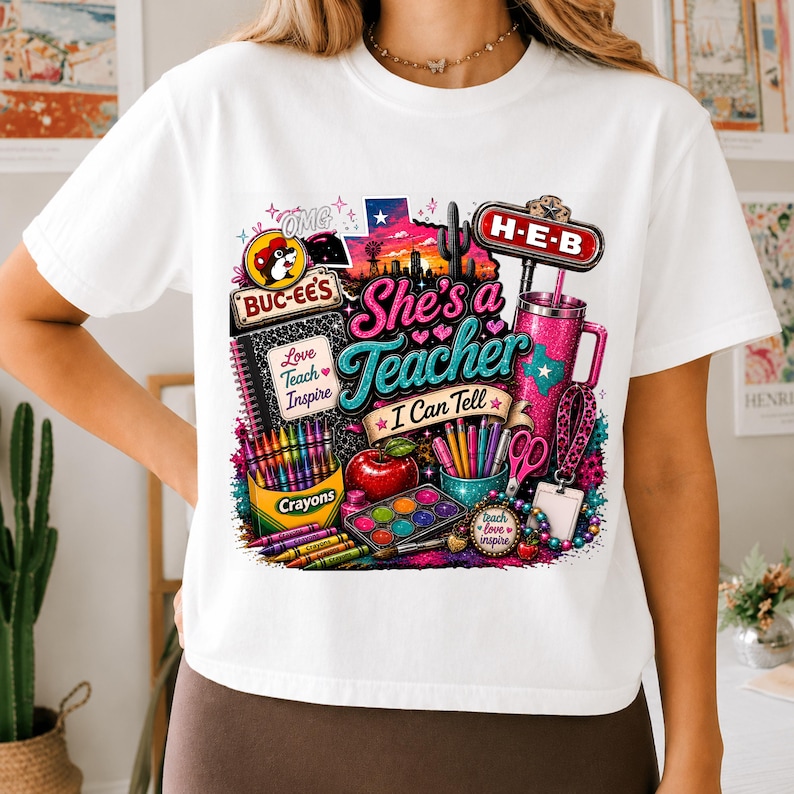 May include: A white t-shirt featuring a colorful graphic print with the text She's a Teacher I Can Tell, Buc-ee's and H-E-B logos, a Texas silhouette, a cactus, a notebook, crayons, a red apple, a paint set, scissors, and a pink tumbler.