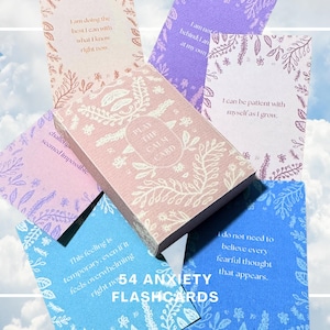 Puede incluir: Un mazo de 54 tarjetas de ansiedad con una caja rosa etiquetada como PLAY THE CALM CARD. Las tarjetas presentan varios colores pastel, incluyendo azul, morado y crema, decoradas con ilustraciones botánicas blancas y afirmaciones.