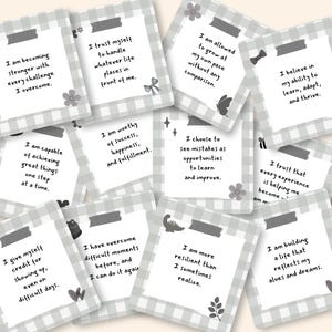 Puede incluir: Una colección de tarjetas cuadradas con un borde de cuadros vichy en gris claro y blanco. Cada tarjeta muestra una afirmación positiva única en texto negro, decorada con pequeños iconos como flores, estrellas, lazos y arcoíris.