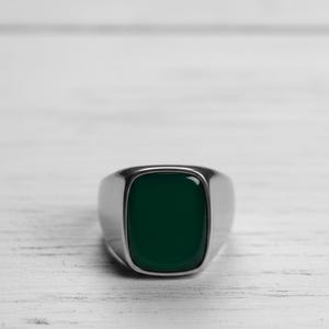 Könnte beinhalten: Ein silberner Ring mit einem rechteckigen, dunkelgrünen Stein. Der Ring hat eine polierte Oberfläche und ein minimalistisches Design. Der Stein ist bündig in das Band des Rings eingesetzt, was einen eleganten Look erzeugt. Dieser Schmuck eignet sich für den Alltag.