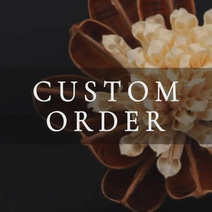 Könnte beinhalten: Ein dekoratives Trockenblumenarrangement mit dunkelbraunen, holzigen, blütenblattartigen Strukturen, die ein Bündel aus hellen, cremefarbenen, zarten und dünnen Blütenblättern umgeben. Der Text CUSTOM ORDER ist in weißen Großbuchstaben überlagert.