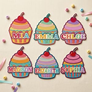 Puede incluir: Seis parches bordados de cupcakes con una cereza en la parte superior y envoltorios de rayas coloridas. Cada parche muestra un nombre en letras gruesas y realzadas: MIA, EMMA, CHLOE, MADISON, ELIZABETH y SOPHIA, con tonos vibrantes y llamativos.