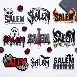 May include: A collection of nine embroidered patches featuring the word Salem in various horror-themed designs, including a skull, a scythe, flames, a ghost, a wooden stake, horns with green slime, monster hands, a bat, and a black cat on a fence.