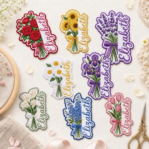 May include: Eight embroidered floral patches featuring bouquets of red roses, yellow sunflowers, purple lavender, white daisies, purple irises, white calla lilies, blue hyacinths, and pink tulips, each with the name Elizabeth stitched in cursive.