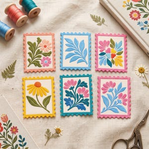Puede incluir: Seis tarjetas rectangulares con forma de sello postal que presentan diseños florales y botánicos en relieve en colores vibrantes como rosa, amarillo, azul y verde. Cada tarjeta tiene un borde festoneado y está dispuesta en dos filas.